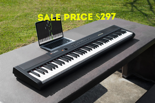 Black portable digital piano on an outdoor table with a laptop; text: "Sale price $297"